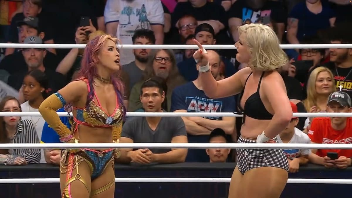 Mina Shirakawa and Toni Storm face off in a wrestling ring, engaged in a heated exchange after their match at AEW Dynamite. The crowd is visible in the background, highlighting the tension of the moment.