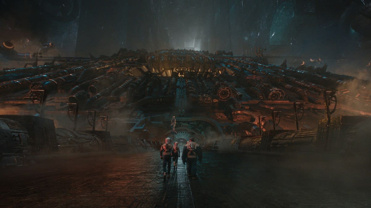 A cinematic scene from 'The Fantastic Four: First Steps,' featuring four characters, including a fiery man and a blue-skinned figure, walking towards a massive, futuristic structure illuminated by eerie lighting, with a misty atmosphere.