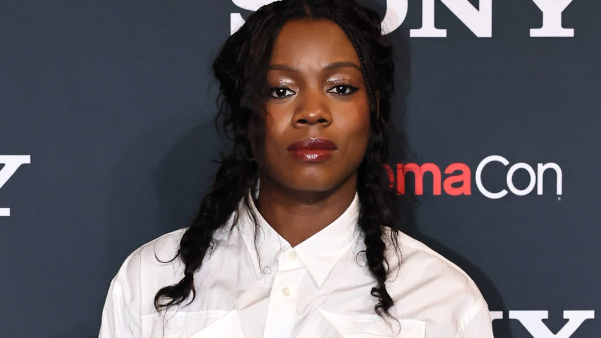 A young woman with braided hair wears a white button-up shirt and poses in front of a dark background featuring the 'Sony' logo and 'CinemaCon' text.