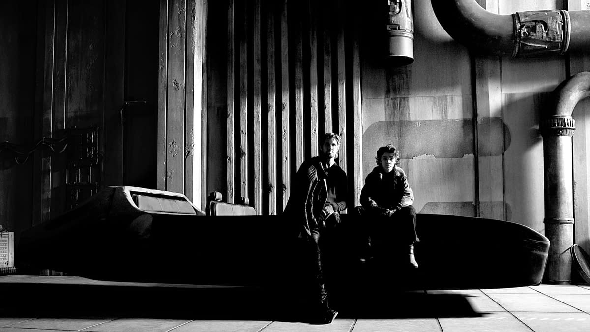 A black and white photograph featuring actors Ryan Gosling and Flynn Gray on the set of 'STAR WARS: STARFIGHTER', seated on a sleek starfighter model against an industrial backdrop.