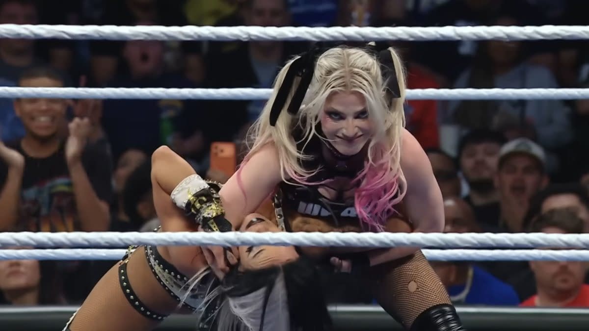 Alexa Bliss prepares to execute the Sister Abigail DDT on her opponent in a WWE SmackDown match, showcasing her intense focus and competitive spirit. The audience is visibly engaged in the background.