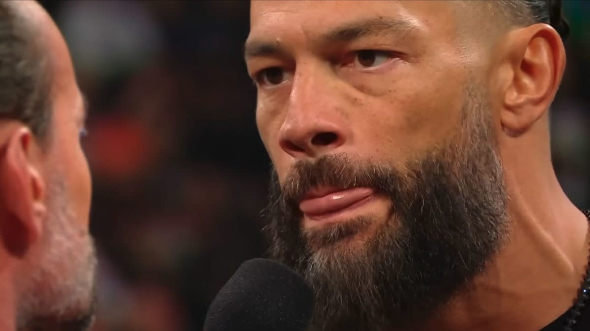 Roman Reigns shows intense emotion while expressing his distaste for CM Punk during a WWE Raw segment, with an emphasis on his focused expression and the microphone in hand.