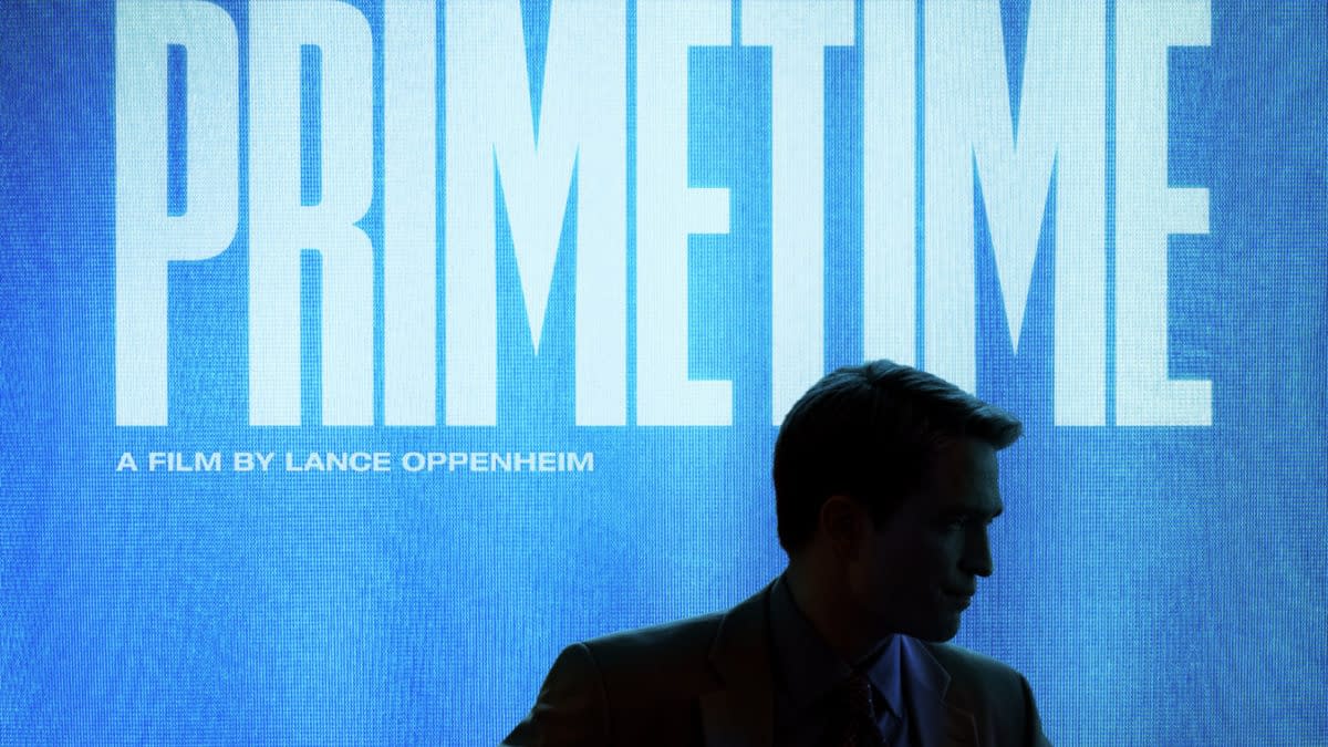 Movie teaser poster for Primetime, featuring a silhouetted man in a suit against a blue TV screen with the title and Robert Pattinson’s name.