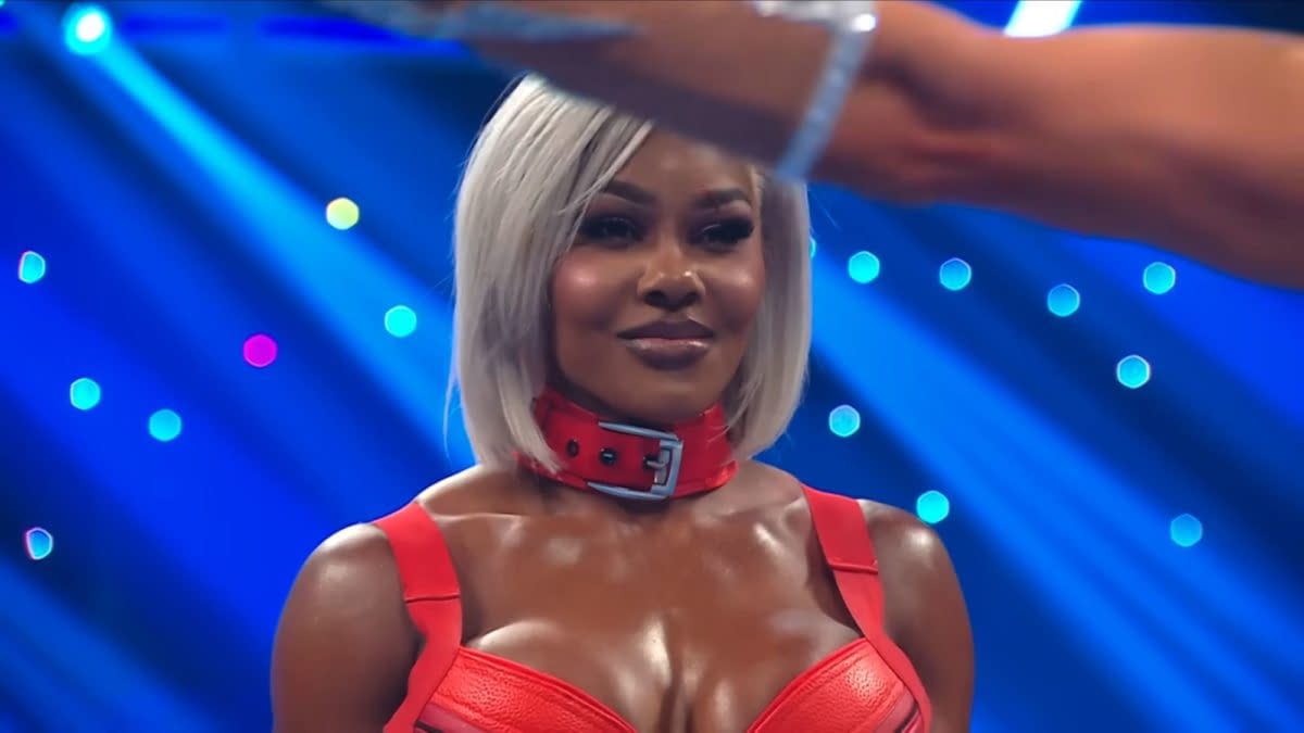 Jade Cargill stands on WWE SmackDown with a unimpressed look as an arm gestures in front of her, under blue stage lights.