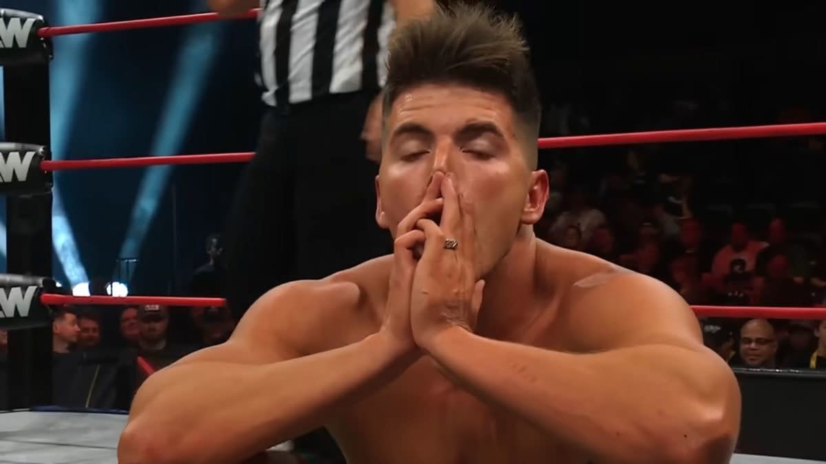Sammy Guevara pauses in the ring during his AEW Collision match with Darby Allin, hands clasped over his face as he catches his breath.