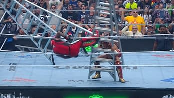 A wrestler in a red outfit is mid-air, falling towards a steel ladder while another wrestler in gold and red prepares for impact in a wrestling ring, surrounded by an excited crowd.
