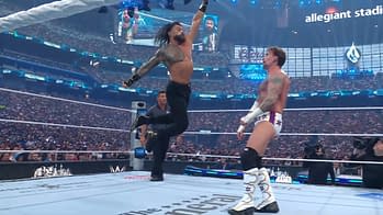 An intense moment in a wrestling match at a large arena, featuring a muscular wrestler celebrating victory while raising his arm triumphantly. Another wrestler stands nearby, looking defeated in this competitive atmosphere.