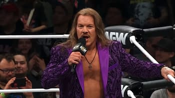 Chris Jericho, wearing a purple sequined jacket, speaks to the audience at AEW Dynamite, with fans visible in the background.