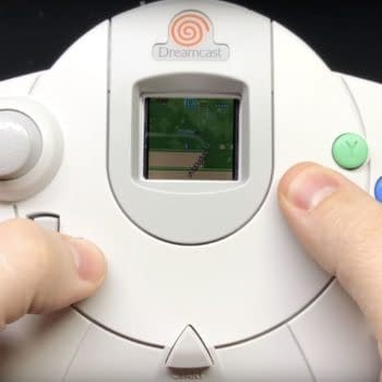 A man holding a Sega Dreamcast controller.