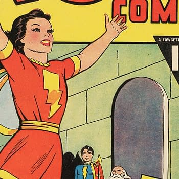 An illustration from Wow Comics #9 featuring Mary Marvel, who is joyfully raising her hands in celebration, wearing a red costume with a lightning bolt emblem. In the background, two other characters are visible, along with a flaming torch.