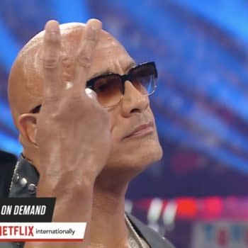 Dwayne "The Rock" Johnson signals John Cena to betray Cody Rhodes with a mysterios two-finger hand gesture.