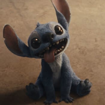 A digital rendering of Stitch, the mischievous blue character from Disney’s live-action 'Lilo & Stitch,' sitting on a flat surface with a playful expression, featuring large eyes and oversized ears.