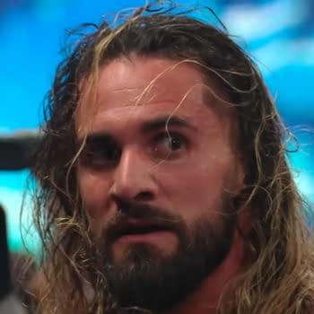 A close-up of Seth Rollins, a professional wrestler with long hair and a beard, looking intensely while a camera is focused on him in the background. The image captures the dramatic atmosphere of a post-show brawl.