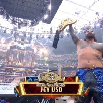Jey Uso holds the World Heavyweight Championship aloft, celebrating his victory at WrestleMania 41, surrounded by a cheering crowd in a large arena. Bright lights and WRESTLEMANIA branding are visible in the background.