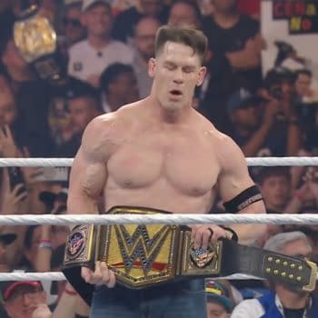 John Cena stands in the wrestling ring holding the WWE championship belt with a look of triumph after defeating Cody Rhodes at WrestleMania 41, surrounded by a cheering crowd.