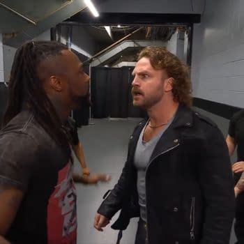 Swerve Strickland and Hangman Page engaged in a fierce verbal confrontation backstage at AEW Dynamite, while other onlookers observe the tension.