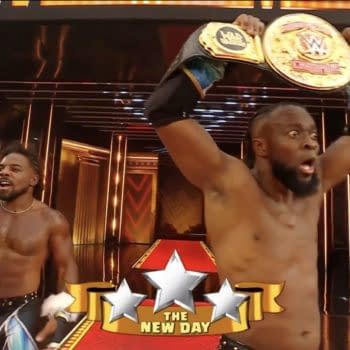 Two wrestlers from The New Day celebrate after winning the tag team titles, holding championship belts high with visible excitement in a brightly lit arena during WrestleMania 41.