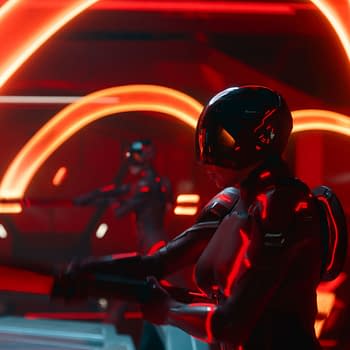 A scene from Disney's live-action movie TRON: ARES, featuring two figures in futuristic armor illuminated by glowing red light patterns, set against a high-tech backdrop.