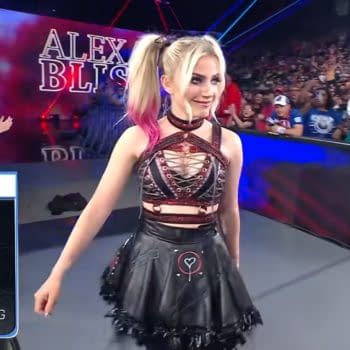 WWE superstar Alexa Bliss makes a stunning appearance during SmackDown, showcasing her signature edgy attire with pink highlights in her hair. A large crowd can be seen in the background, displaying excitement.