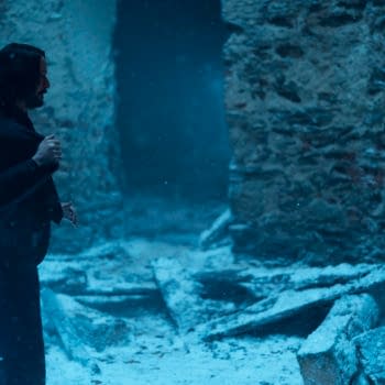 A scene from the film 'Ballerina' featuring Keanu Reeves as John Wick confronting Ana de Armas as Eve in a snow-covered, damaged environment with visible debris.