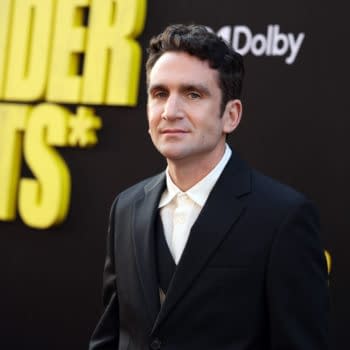 Jake Schreier at the world premiere of Marvel Studios' "Thunderbolts*" in Hollywood, wearing a black suit and white shirt, against a background featuring the event title in bold yellow letters.