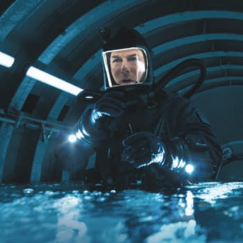 A scene from 'Mission: Impossible - The Final Reckoning' featuring a character in a dark, futuristic environment, wearing a diving suit and helmet with lights, conveying a sense of urgency and action.