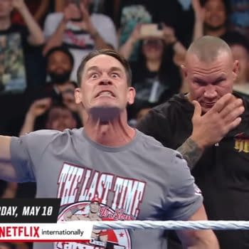 John Cena, displaying an intense expression while holding the WWE Championship belt, is confronted by Randy Orton, who stands in the background looking ready to ambush him. The crowd is energized in the background on WWE SmackDown ahead of WWE Backlash.