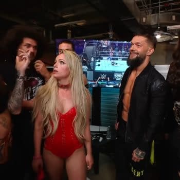 A group of wrestlers from the Judgment Day faction on WWE Raw, showing various expressions of tension and disagreement among them. The setting is backstage, with a wrestling event visible on a monitor in the background.