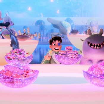 In a vibrant animated scene from Disney and Pixar's 'Elio,' a cheerful boy named Elio, surrounded by colorful alien characters, delights in a table full of sparkling treats and desserts. This whimsical setting showcases the film's imaginative landscape as Elio embarks on his intergalactic adventures.