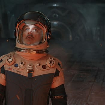 A still from 'The Fantastic Four: First Steps' featuring three characters in futuristic space suits, with one character named Reed Richards/Mister Fantastic at the center, looking surprised. The setting conveys a dramatic and adventurous atmosphere, hinting at the Marvel Studios narrative.