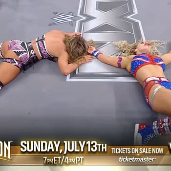 Blake Monroe and Jordynne Grace lie on the wrestling ring canvas, appearing exhausted after a match, with their bodies positioned on either side of the NXT logo.