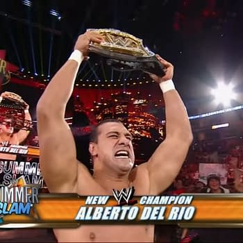 A man with a muscular build, Alberto Del Rio, triumphantly raises the WWE Championship belt above his head, celebrating victory at SummerSlam 2011, as a vibrant crowd cheers in the background and the SummerSlam logo is displayed prominently.