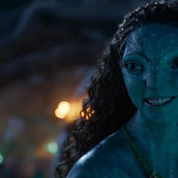 A scene from 'AVATAR: FIRE AND ASH' featuring two Na'vi characters, Lo'ak and Tsireya, engaged in a friendly conversation. They have distinctive blue skin and decorative elements in their hair and clothing.