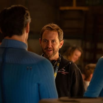 Director Matt Shakman talks with actors on the set of 'The Fantastic Four: First Steps,' set in a studio environment, featuring crew members in the background.