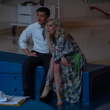 Still from 'The Fantastic Four: First Steps' featuring Pedro Pascal as Reed Richards and Vanessa Kirby as Sue Storm, seated together on a blue surface in a futuristic setting.