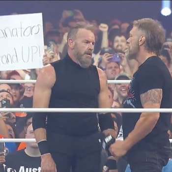 Two wrestlers, Cope and Christian Cage, face each other in a wrestling ring at AEW All In Texas, with a cheering crowd in the background. A sign in the audience reads "Rianators Stand UP!"