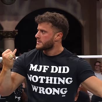 A wrestler wearing a black shirt with the phrase "MJF DID NOTHING WRONG" gestures animatedly while other fans are visible in the background on AEW Dynamite. The scene captures the intensity and excitement of a live wrestling event.