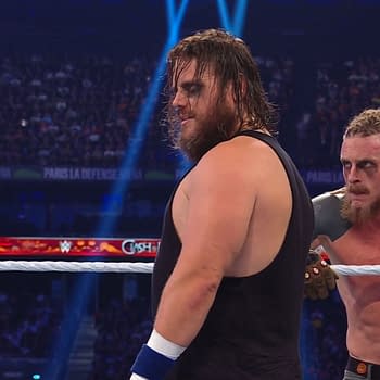 Joe Gacy and Dexter Lumis from The Wyatt Sicks are engaged in a wrestling match during WWE Clash in Paris 2025, with bright lights illuminating the arena.