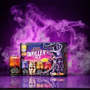 A vibrant box of Angry Orchard's Thriller Pack featuring twelve cans, prominently displaying a blood orange can design. Behind it, a spooky purple and smoke background adds a dramatic effect.