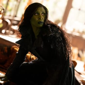 Cynthia Erivo portrays Elphaba in the film 'WICKED FOR GOOD,' wearing a dark, textured costume and exhibiting a serious expression in a richly decorated setting.