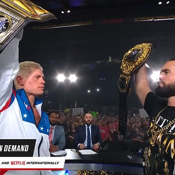 Cody Rhodes and Seth Rollins hold up their championship belts triumphantly after WWE WrestlePalooza, with a cheering crowd in the background. The scene captures the excitement of the event with lights shining above.