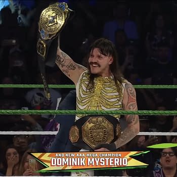 Dominik Mysterio triumphantly holds the AAA Mega Championship belt above his head while wearing a skeletal-patterned outfit, surrounded by enthusiastic fans in a wrestling ring.