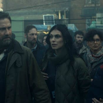 A scene from 'Greenland 2: Migration' featuring characters John Garrity, Allison Garrity, Dr. Casey Amina, and Nathan Garrity navigating a crowded, chaotic environment filled with people in a dystopian setting.