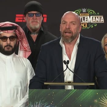 A press conference event featuring several speakers, including individuals in traditional Middle Eastern attire and iconic wrestling figures, discussing WWE WrestleMania 43 taking place in Saudi Arabia.
