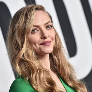 Amanda Seyfried poses with a subtle smile on the red carpet, wearing a green outfit. The image captures the glamour of a celebrity event, highlighting her as a prominent figure in the entertainment industry.