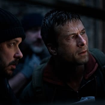 Director Edgar Wright and actor Glen Powell are captured in a tense moment on the set of "The Running Man," exhibiting expressions of focus and intensity.