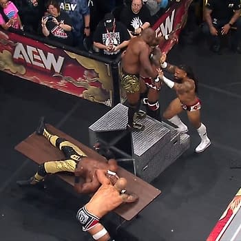 A wrestling match at AEW WrestleDream featuring several competitors in an active scene. One wrestler is seemingly being set up for a move on a table while others are engaged in direct action in the ring.
