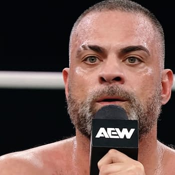 Eddie Kingston delivers an emotional promo in a wrestling ring, holding a microphone and appearing visibly intense and passionate.