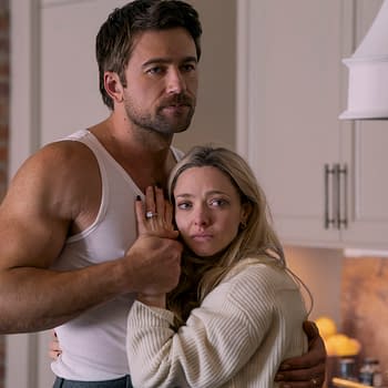 Brandon Sklenar as Andrew Winchester and Amanda Seyfried as Nina Winchester in a dramatic embrace in a kitchen setting. The scene reflects tension with emotional expressions amidst a domestic backdrop.