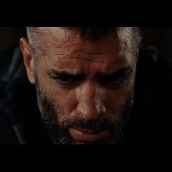 A close-up of Mark Briscoe's face, showing intense emotions, with a beard and a serious expression as he reflects before his TNT Championship match. The AEW Full Gear logo is featured at the bottom corner.